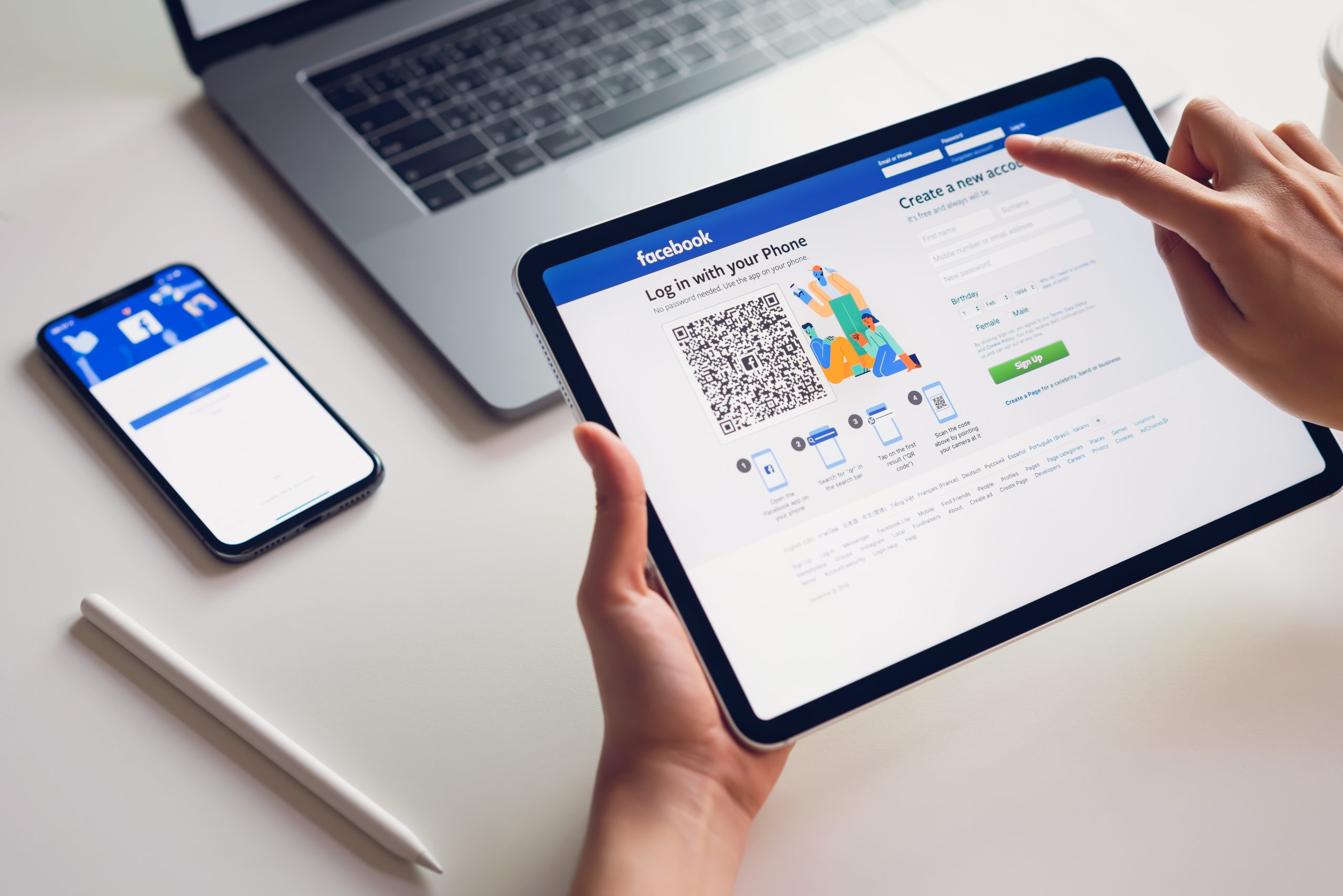Bangkok, Thailand - February 07, 2019 : hand is pressing the Facebook screen on apple iphone x ,Social media are using for information sharing and networking.